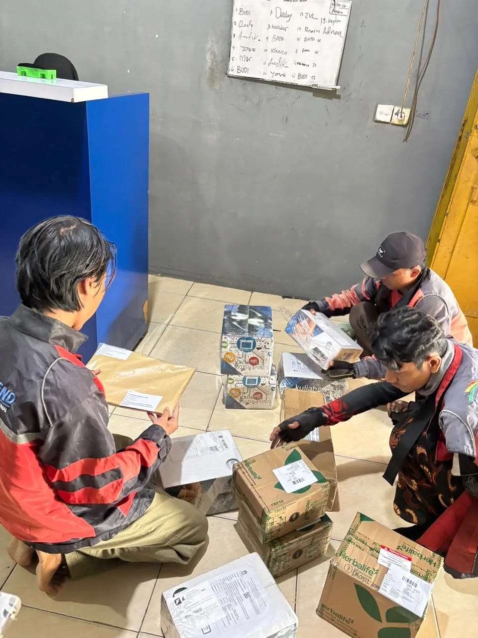 Tim mengecek data paket pengiriman